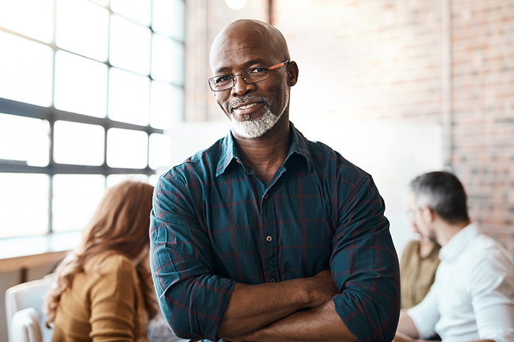 Image of man in office with coworkers behind him