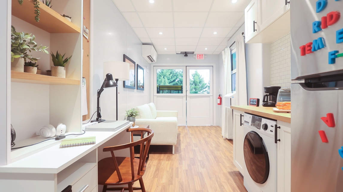 The inside of the escape trailer decorated as an apartment with furniture and appliances.