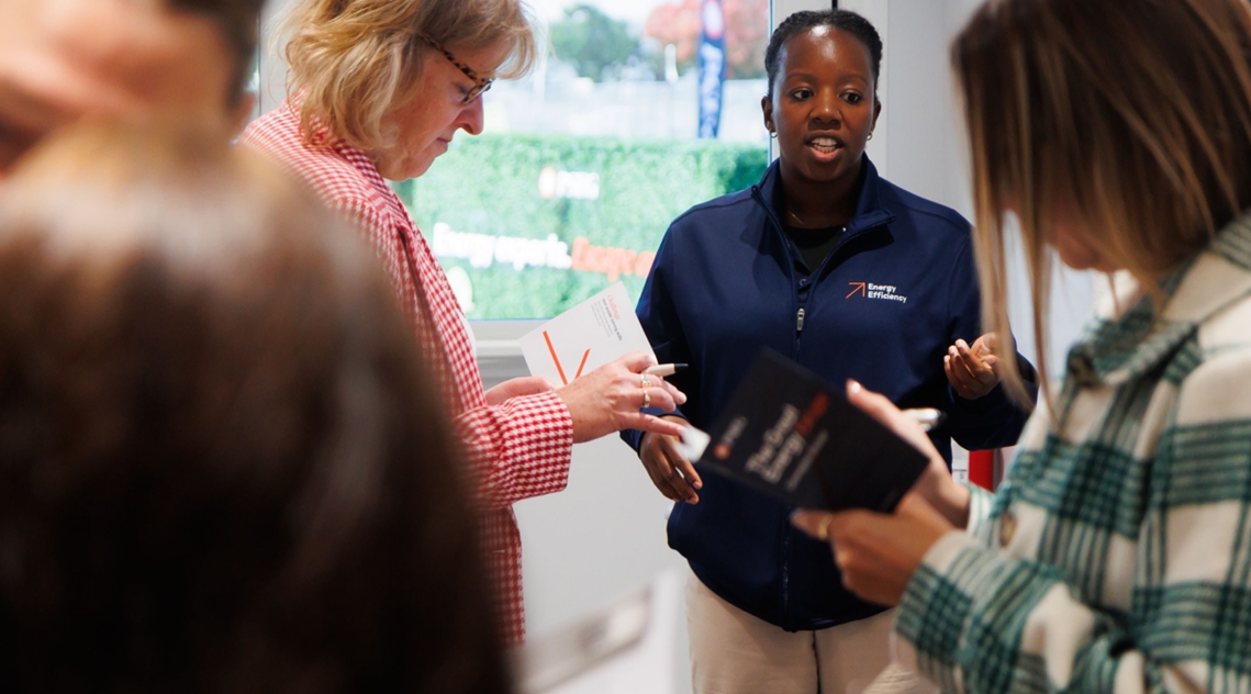 A Public Service Electric & Gas Co. employee speaking with participants as they read their gameplay booklet.