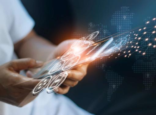 Person holding a smartphone with glowing digital icons and network connections overlayed, symbolizing technology and global connectivity