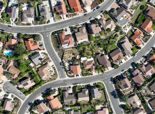 Aerial view of a suburban neighborhood with curved streets and houses surrounded by greenery