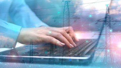 Hands typing on laptop with overlay of power lines and digital network