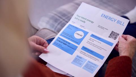 A person holding a printed utility bill